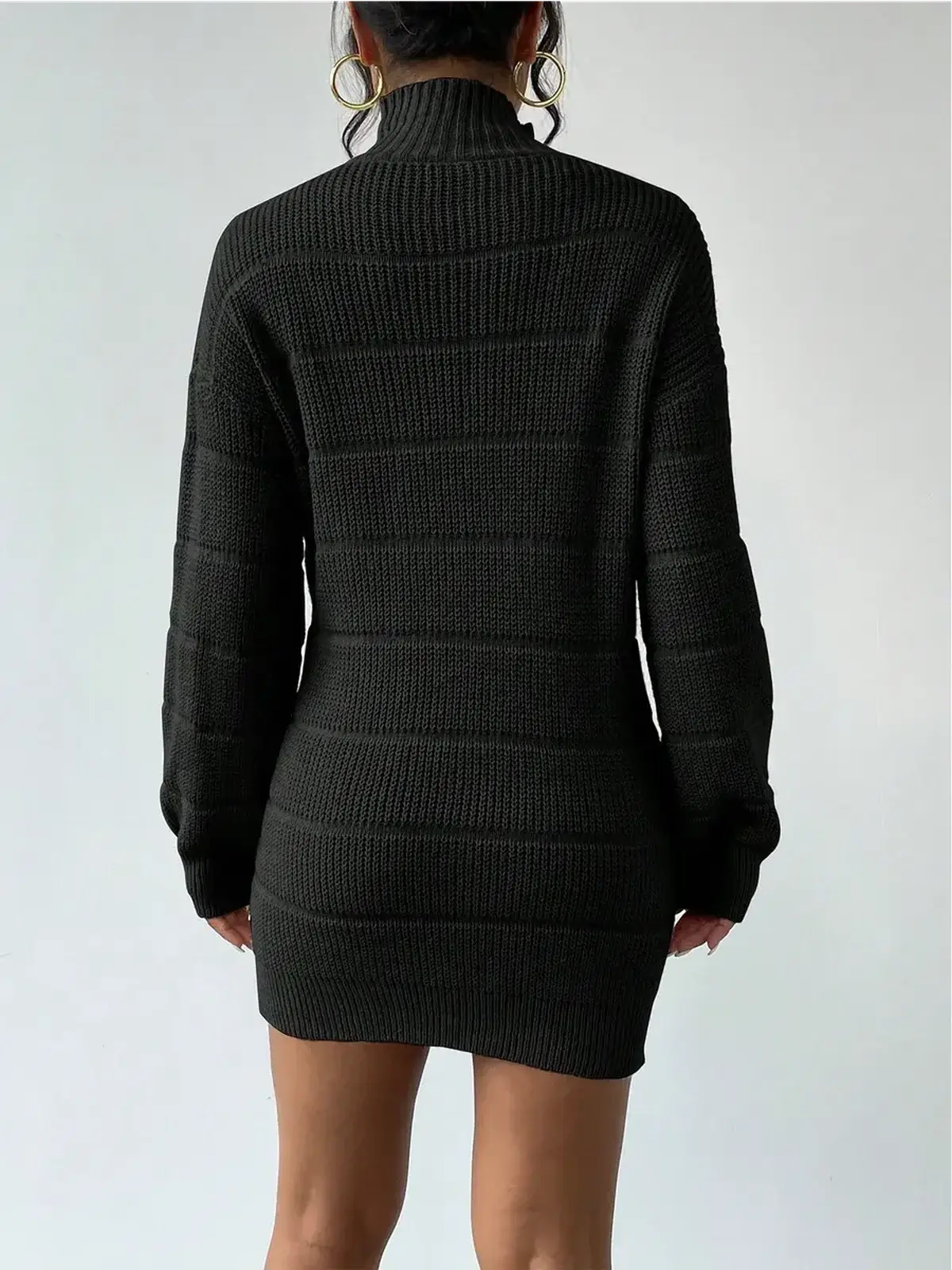 Back view of a cozy black mini dress with a high turtleneck and long sleeves, perfect for stylish outings.