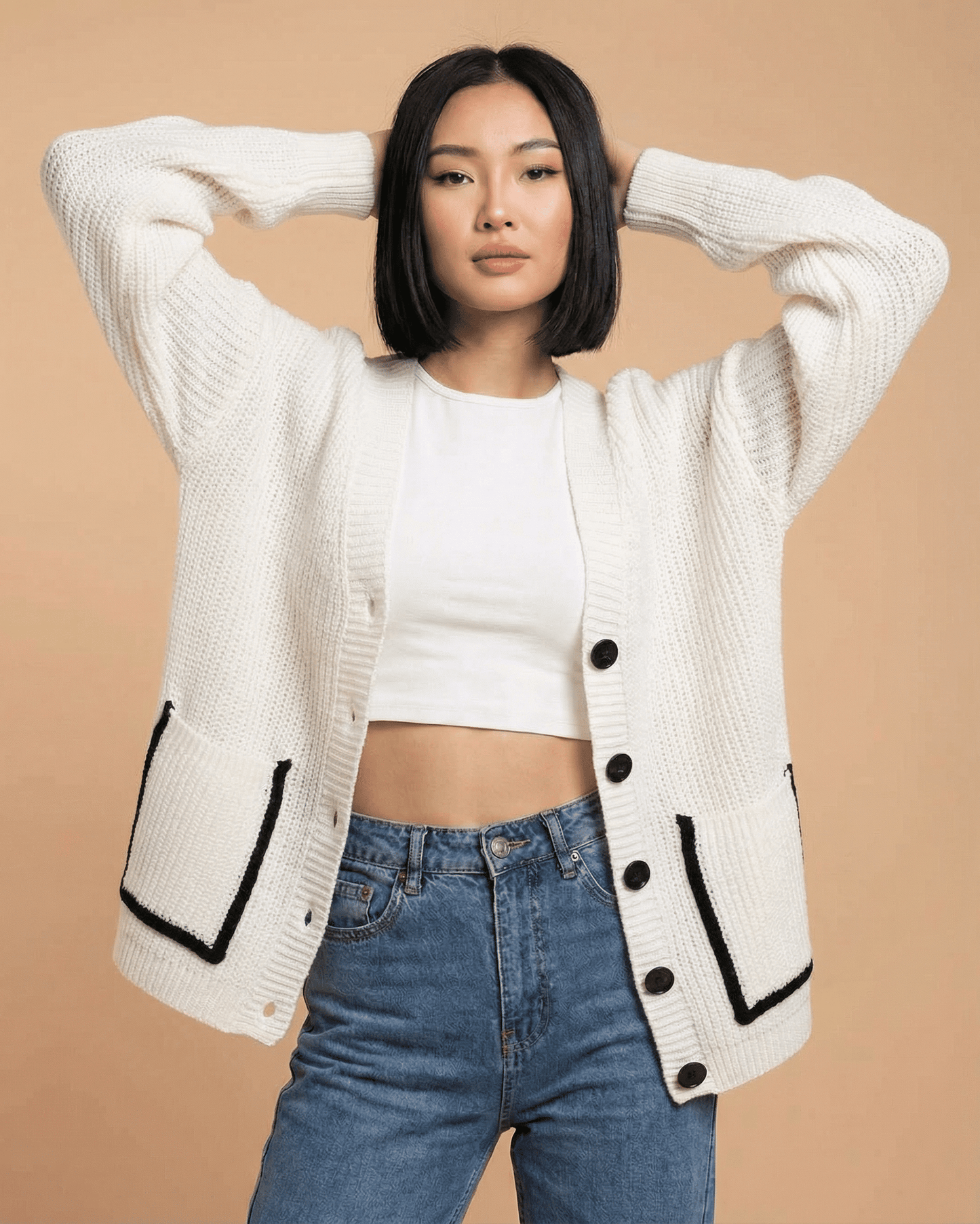 Model wearing the Elara Cardigan by Slimona, a loose fit v-neck cardigan with color block design and button closure.