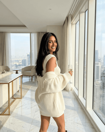 Elysia Mini Dress by Slimona displayed on a model, showcasing the chic fitted knit bodycon style in a bright interior.