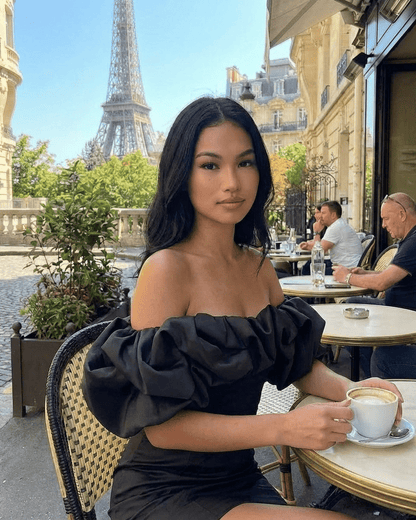 Elysia Mini Dress by Slimona, off-the-shoulder style in black, with dramatic ruffle trim, set in Paris.