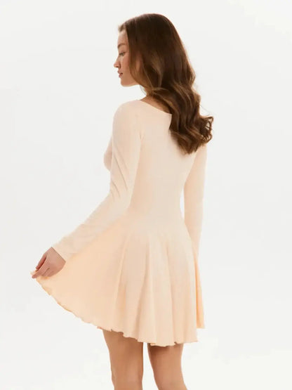 Back view of a Flare Fit Mini dress in soft peach, showcasing long sleeves and a flared skirt design.