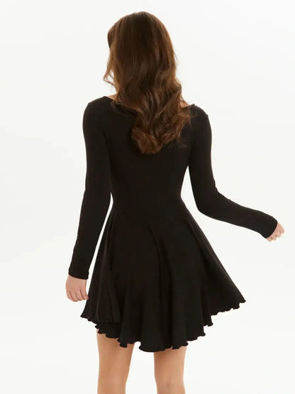 Back view of a woman in a black mini dress with flared skirt and long sleeves, perfect for party or cocktail occasions.