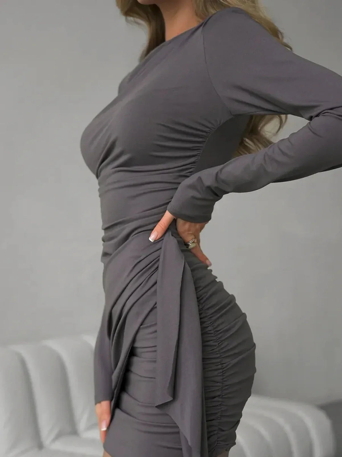 Close-up of a model wearing a Gray Allure long sleeve mini dress, showcasing its ruched design and body-hugging silhouette.