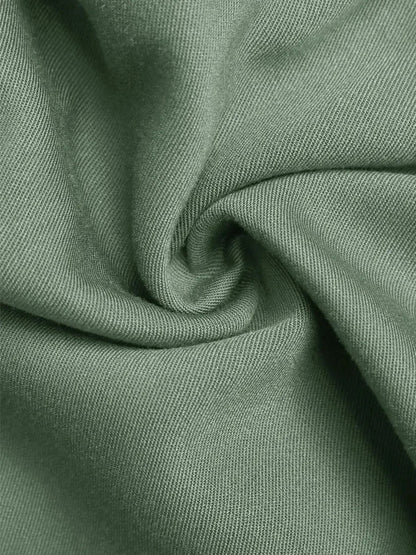 Close-up of soft green viscose fabric showcasing its texture, ideal for summer dresses.