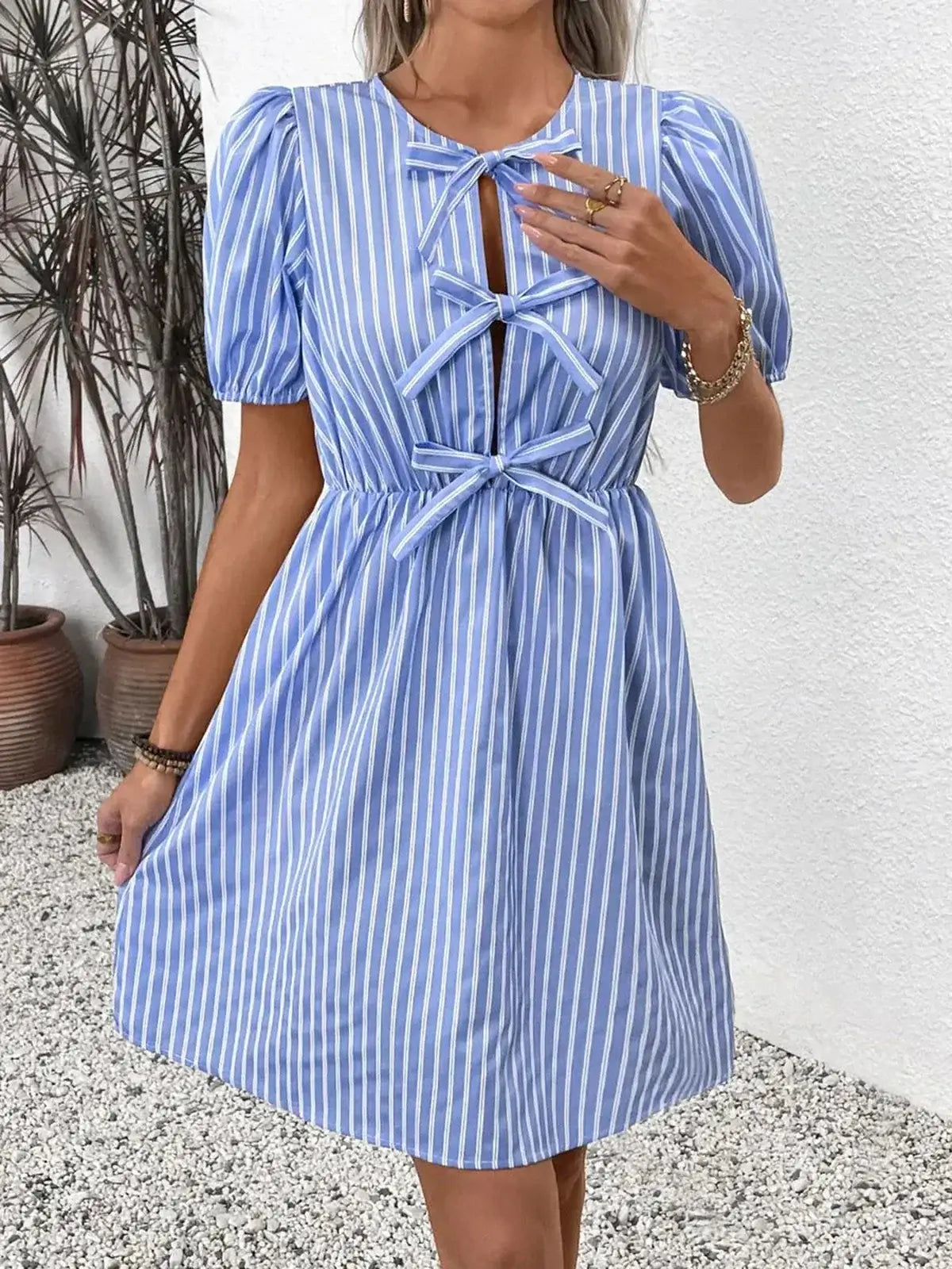 Harbor Stripe Mini Dress featuring a blue and white striped design with bows and puff sleeves, perfect for summer occasions.
