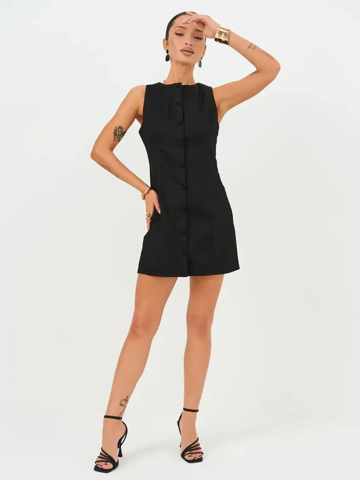 Model wearing the Icon Edge Mini Dress, a sleek black sleeveless button-up dress with a modern silhouette.