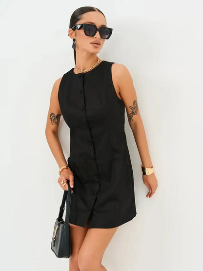 Sleek black Icon Edge Mini Dress with button detail, styled with accessories, perfect for summer occasions.