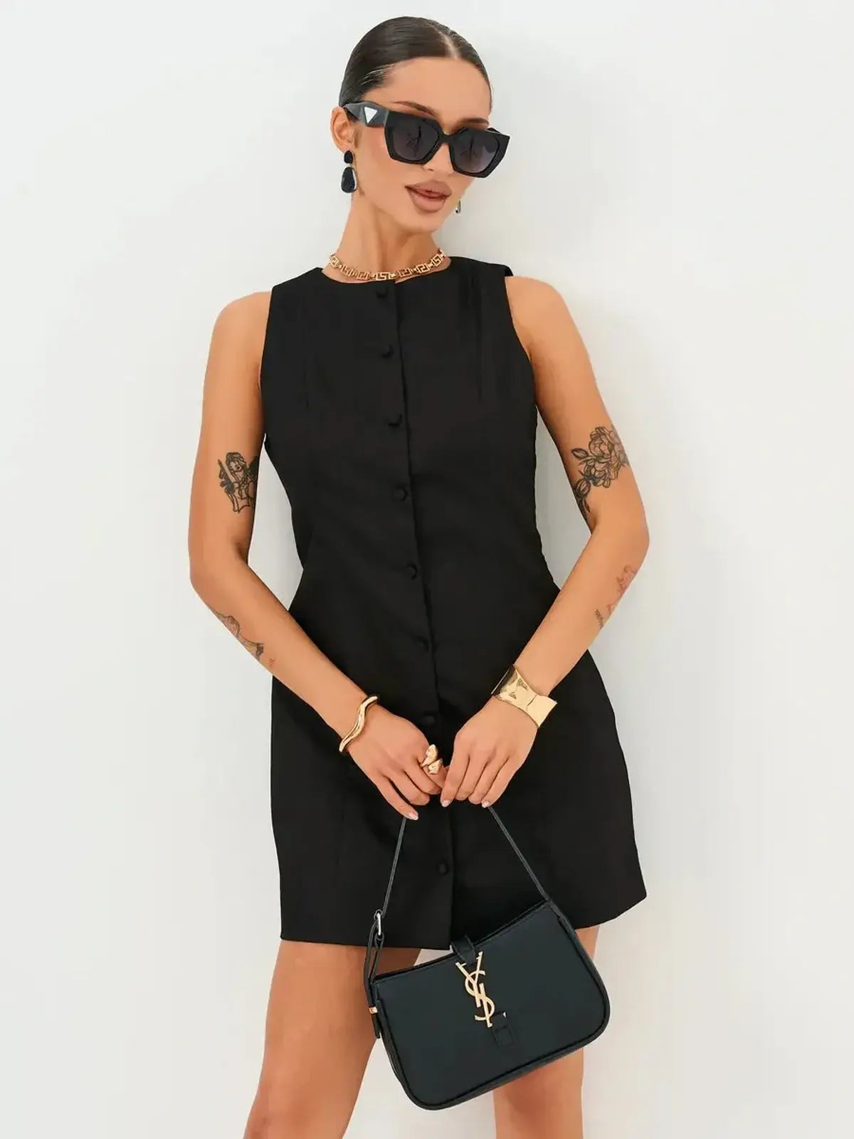 Stylish woman in a black mini dress with button detail, sunglasses, and a chic handbag, perfect for summer or formal occasions.