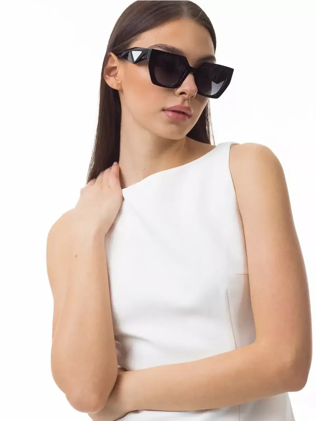 Model wearing a sleek white mini dress with sunglasses, showcasing minimalist summer elegance.