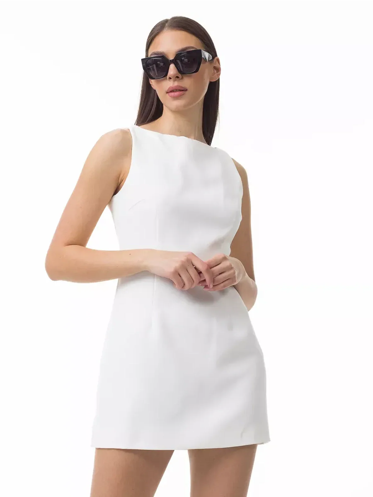 Model wearing a sleek white Iconic Curve Mini Dress, showcasing a minimalist design and sophisticated style.