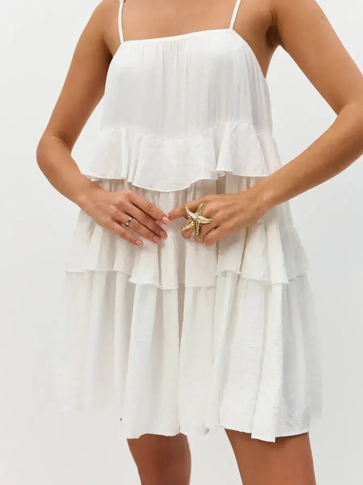 Riviera Ruffle white summer dress with tiered ruffles and delicate shoulder straps, ideal for weddings and casual outings.