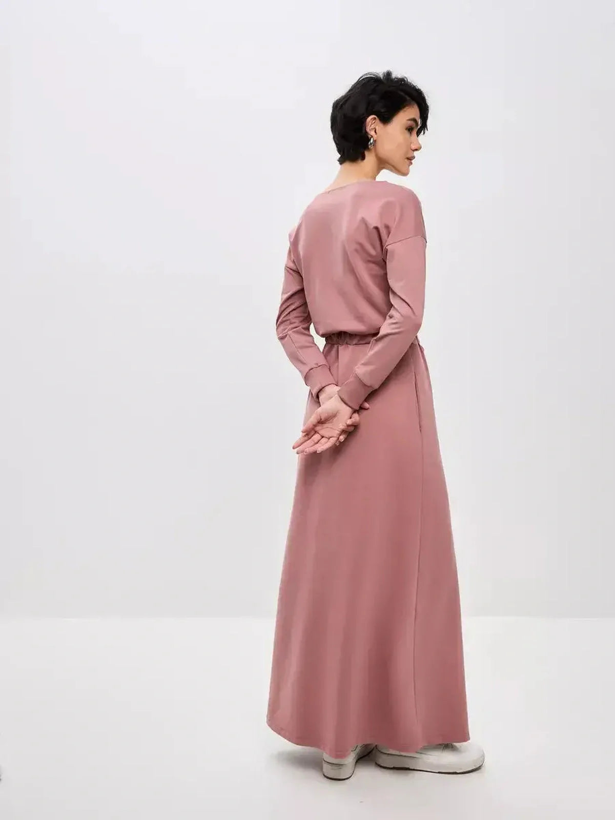 Back view of a woman in a dusty pink Blush Lounge Maxi Dress, showcasing its elegant silhouette and soft fabric.
