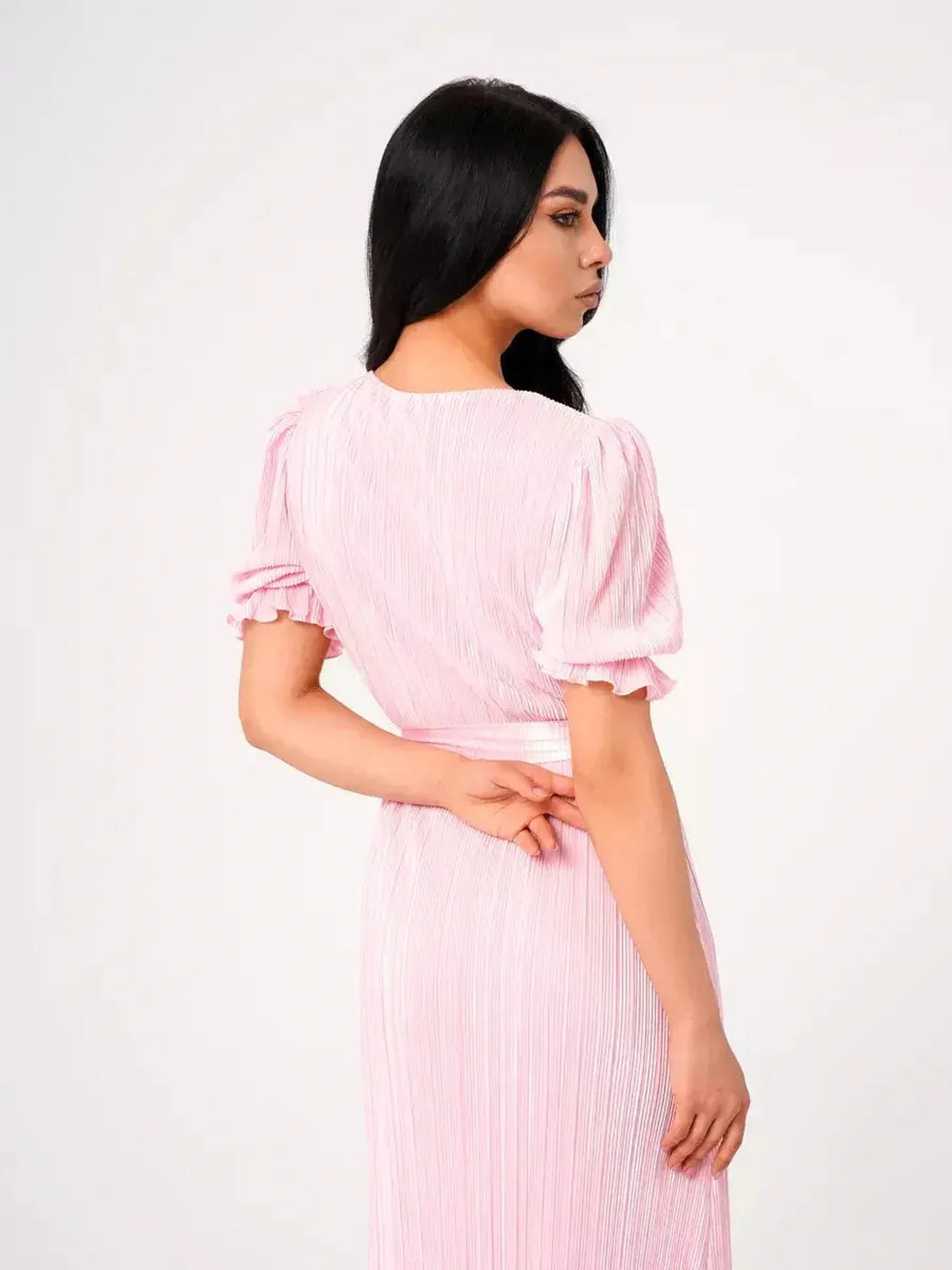 Back view of the pink pleated Celeste Maxi Dress featuring puff sleeves and a flattering tie waist.