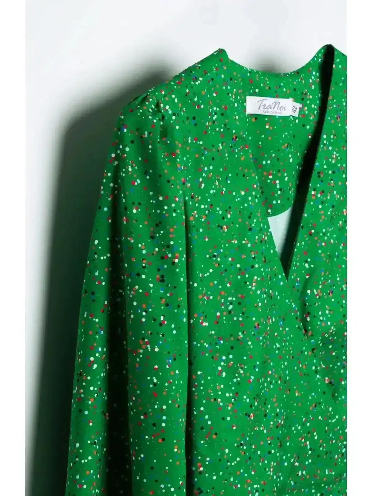 Vibrant green midi dress with a wrap design and colorful speckled dot print, perfect for summer occasions.