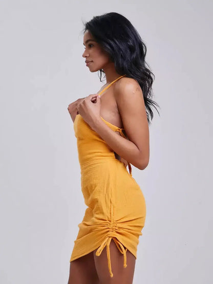 Side view of a woman wearing a yellow mini dress with adjustable straps, perfect for summer occasions.