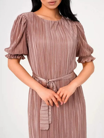 Close-up of a woman wearing the Celeste Maxi Dress in light cappuccino with elegant pleats and puff sleeves.