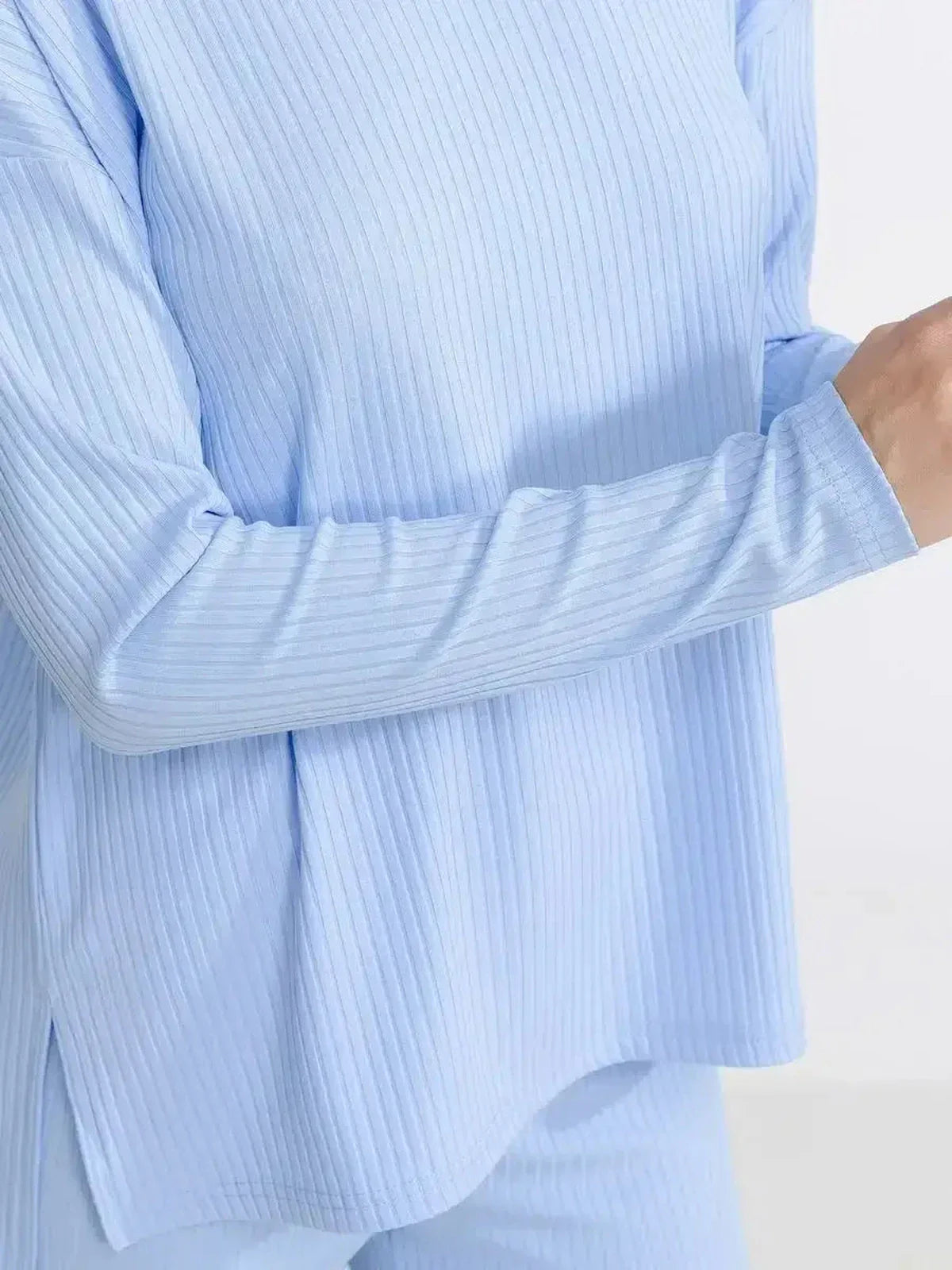 Close-up of a woman wearing an ultra-soft ribbed knit top from the Cloudline Lounge Set in light blue.