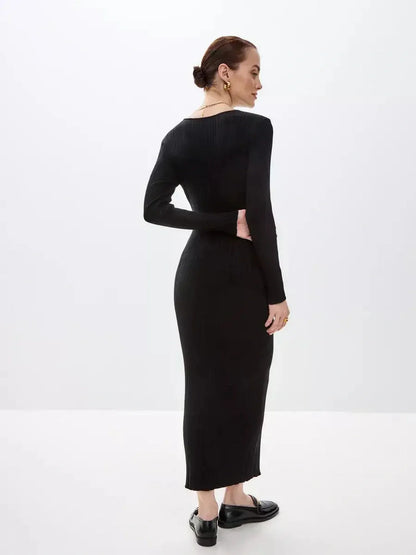 Back view of a woman wearing a sleek black sculpted rib maxi dress, showcasing its elegant silhouette and long sleeves.