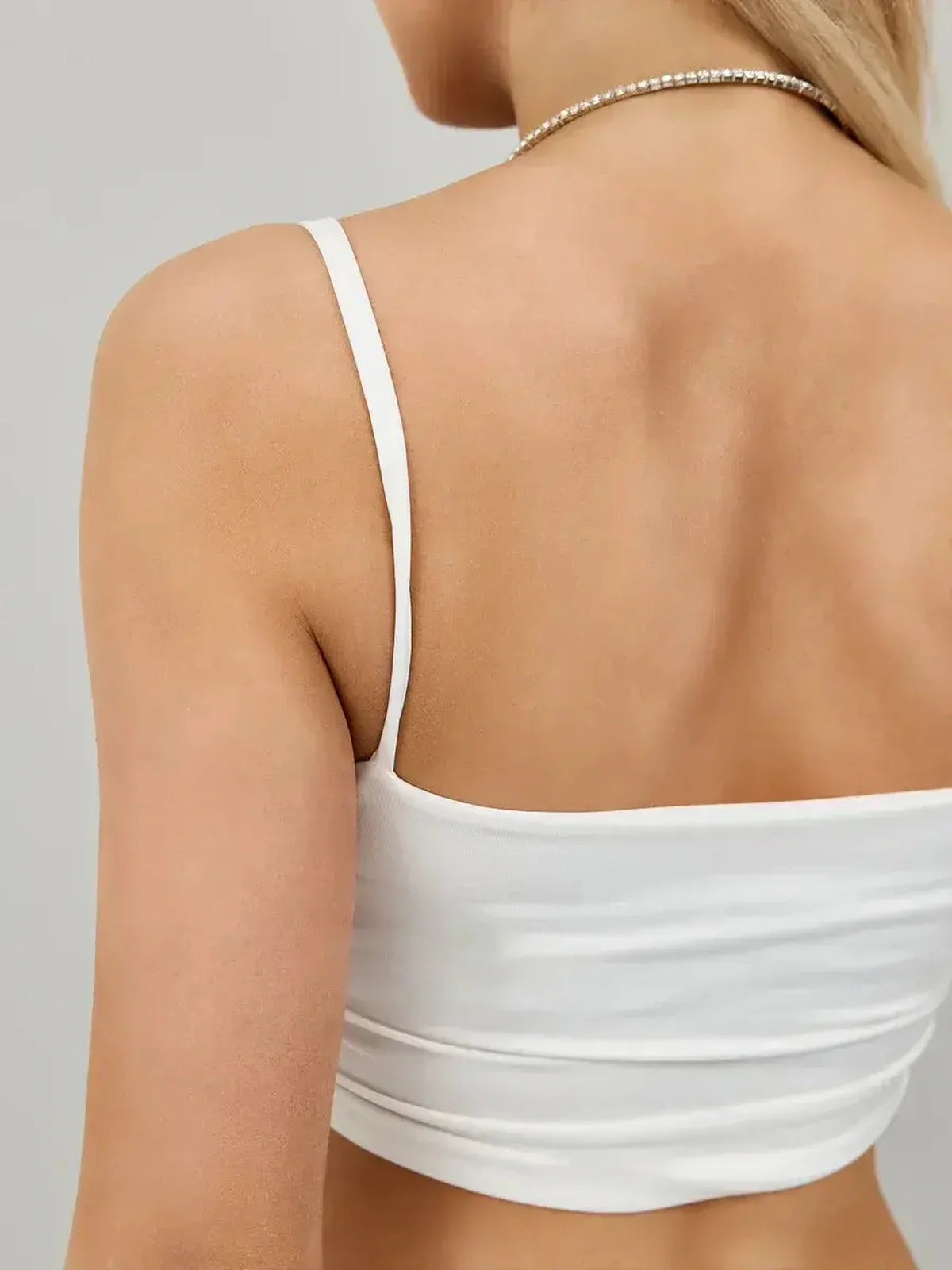 Ruched white crop top back view featuring delicate straps, perfect for summer dresses and cocktail attire.