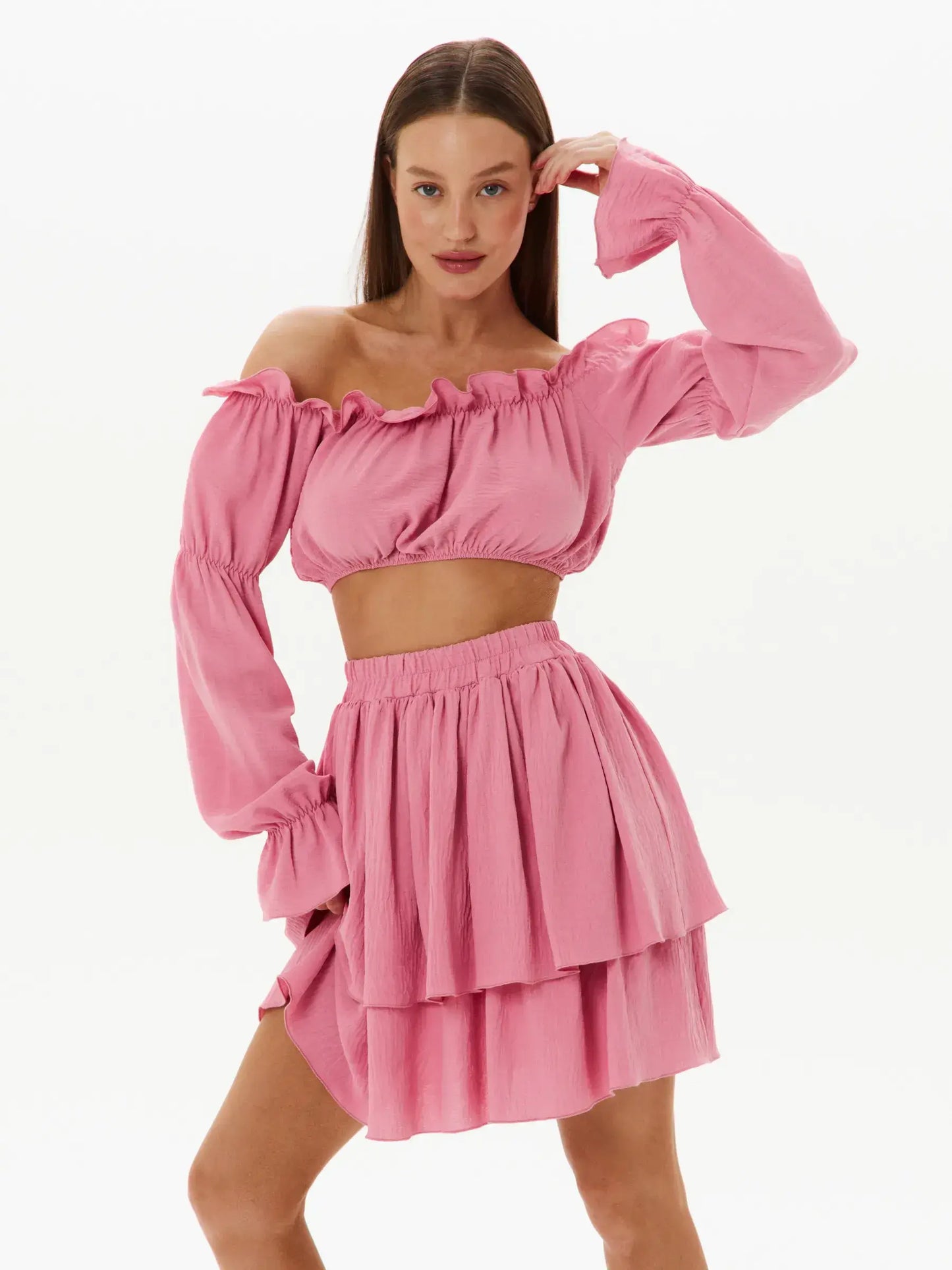 Feminine tiered ruffle set featuring an off-shoulder crop top and layered mini skirt in pink, perfect for summer and special occasions.