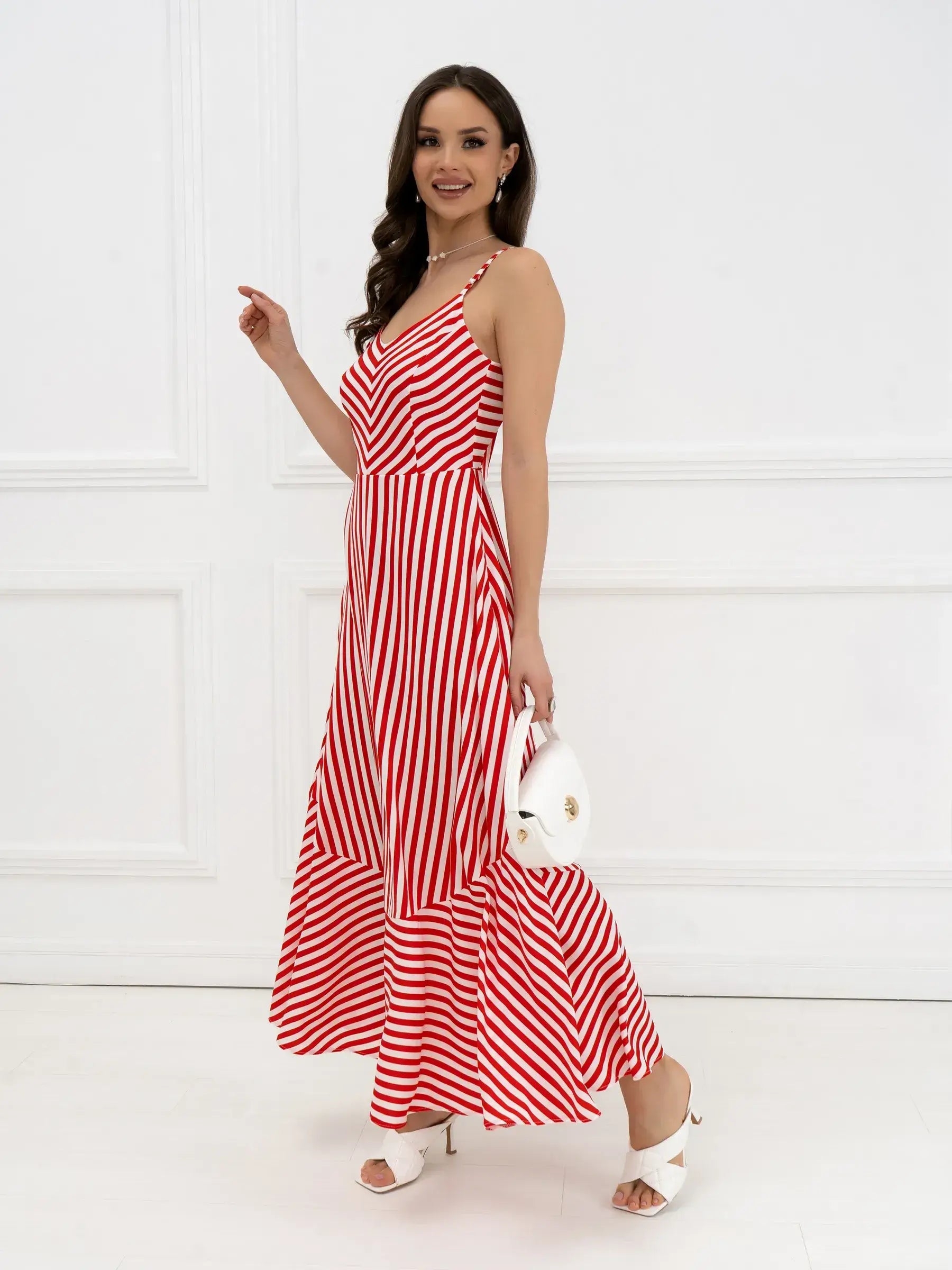 Model wearing a red-and-white striped maxi dress with a tiered hem, ideal for summer events and weddings.
