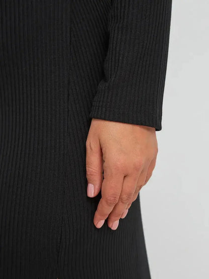 Close-up of a woman's hand on a ribbed black midi dress, showcasing its elegant texture and design.
