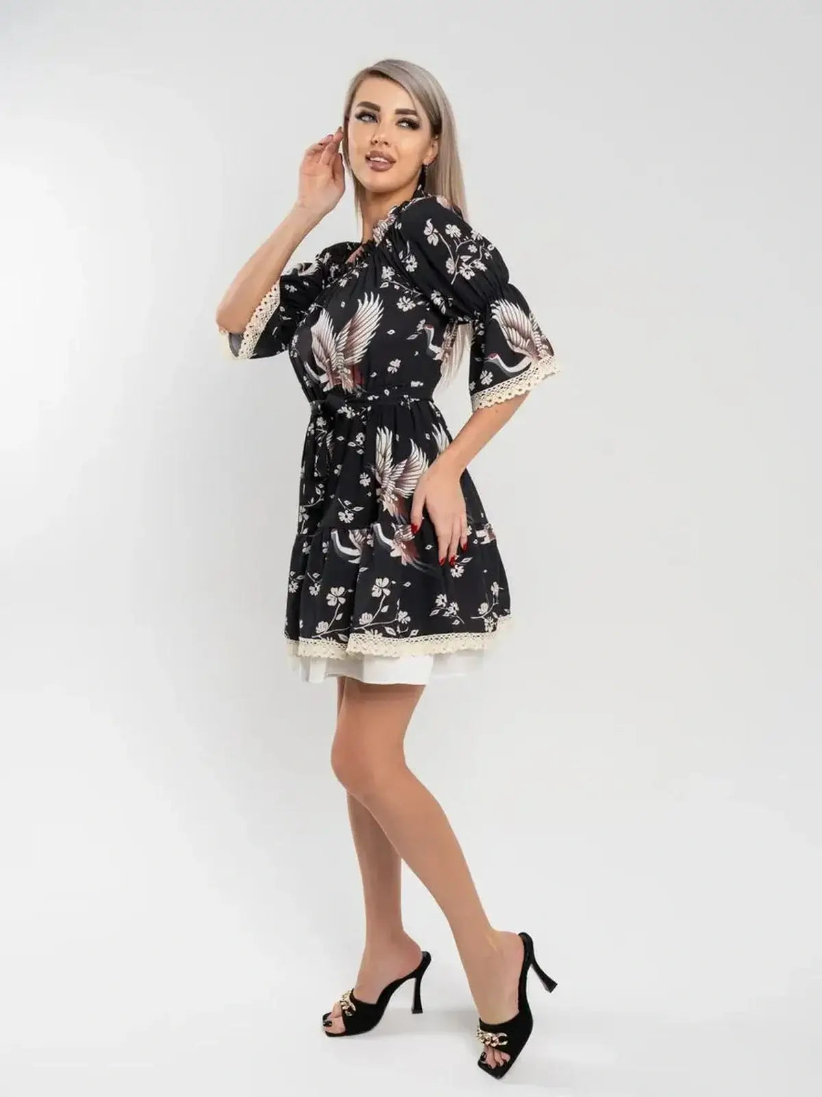 Crane Bloom black mini dress featuring floral print and cinched waist, perfect for weddings or summer events.