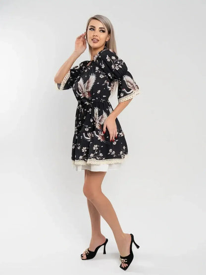 Crane Bloom black mini dress featuring floral print and cinched waist, perfect for weddings or summer events.