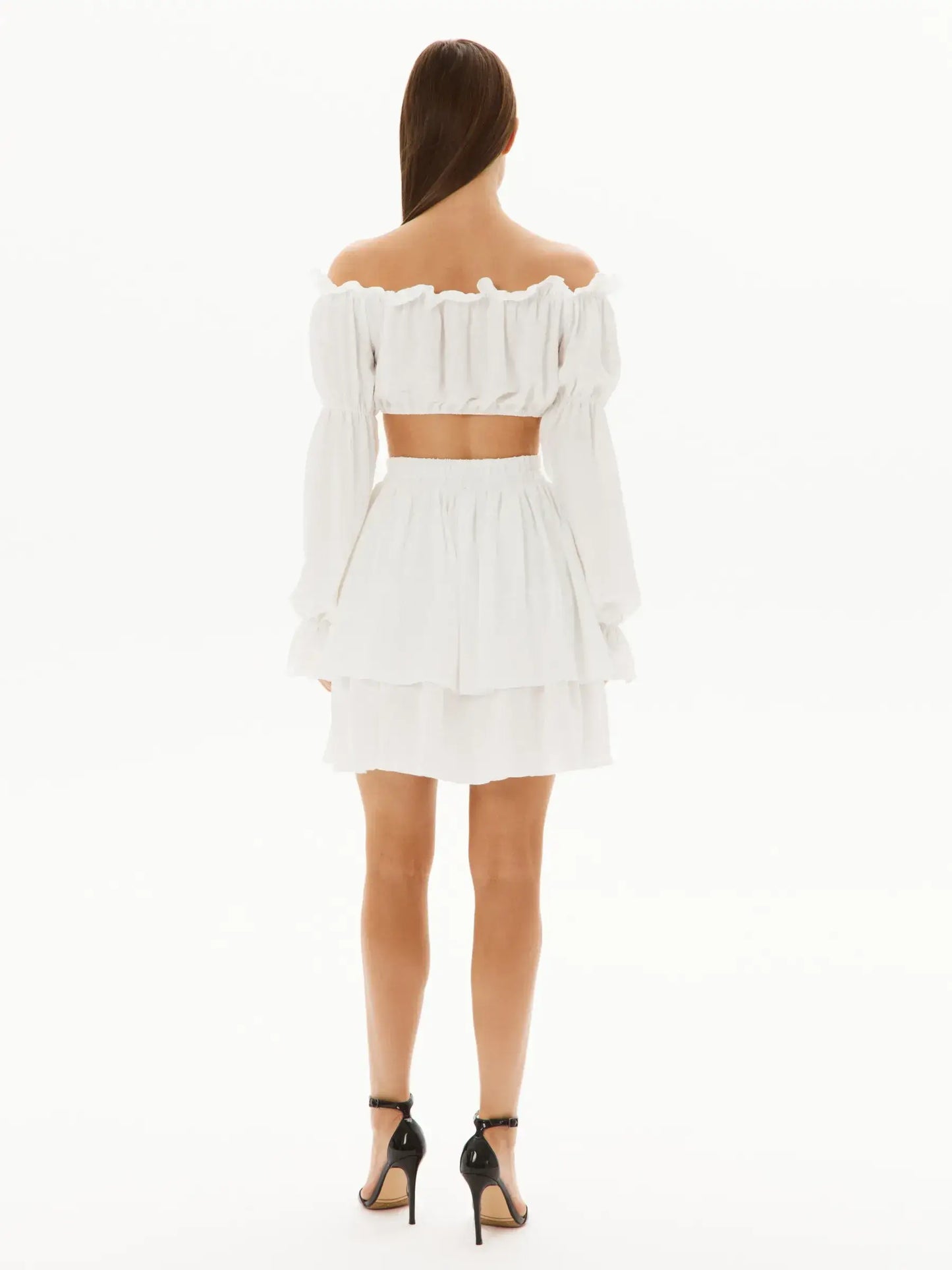 Back view of a stylish white ruffle set featuring an off-shoulder top and layered mini skirt, perfect for summer occasions.