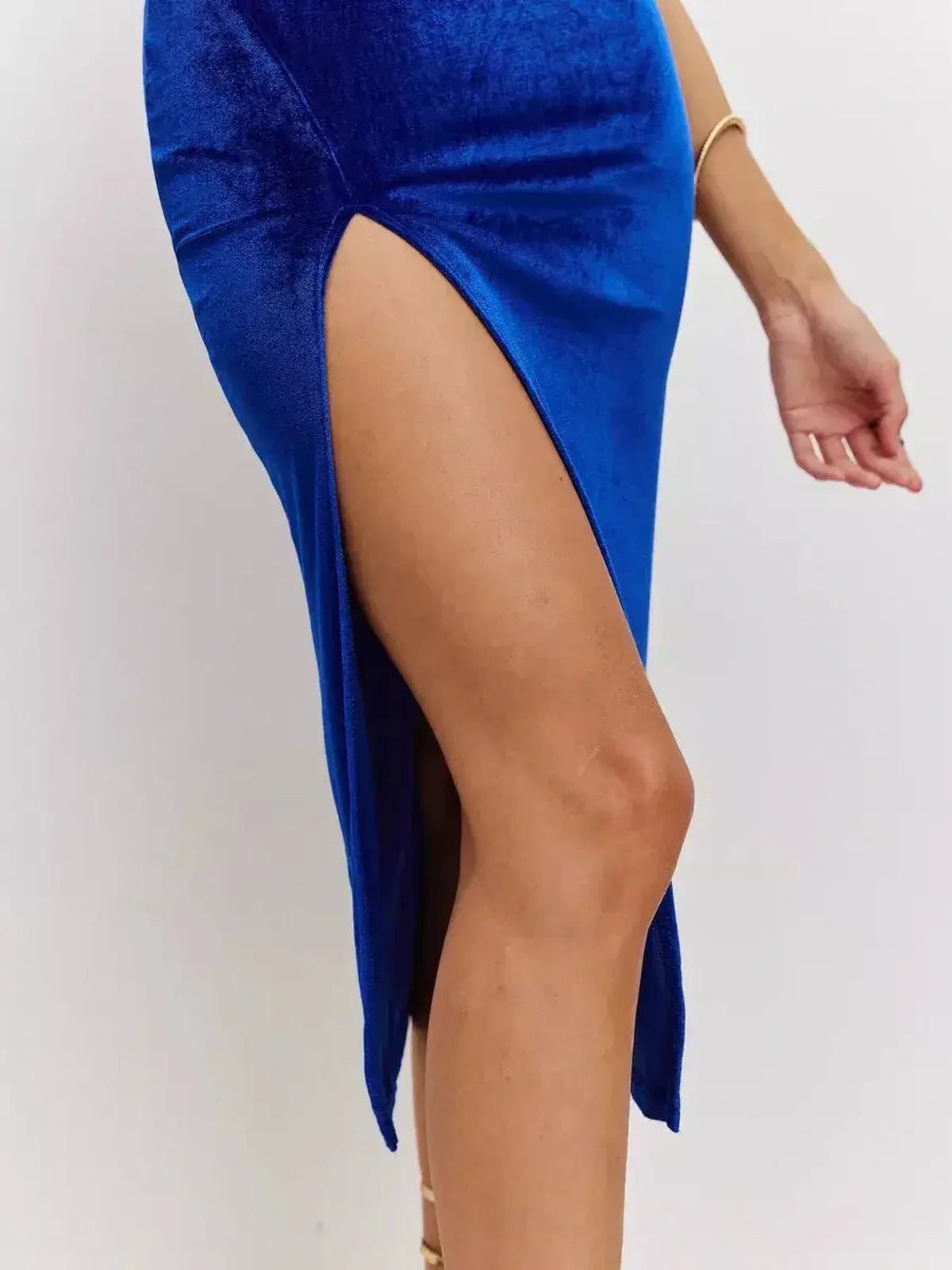 Close-up of a thigh-high slit on a luxe blue velvet midi dress, perfect for weddings and formal events.
