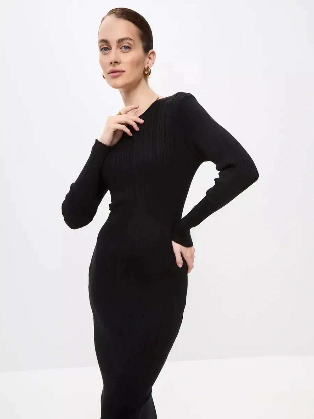 Model showcasing a black Sculpted Rib Maxi Dress with a streamlined silhouette and long sleeves.