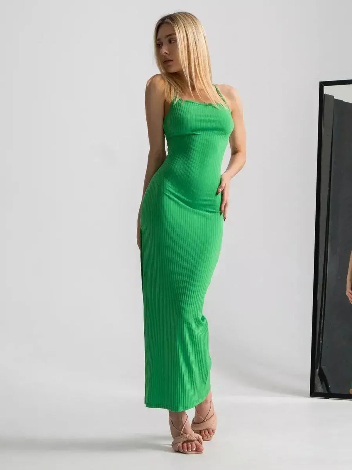Model in a sleek emerald green maxi dress showcasing a strappy back, perfect for summer events and weddings.