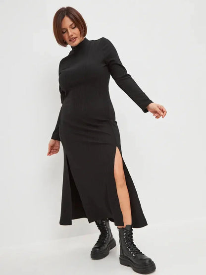Black midi dress with ribbed texture and side slit, styled with combat boots for a chic, modern look.