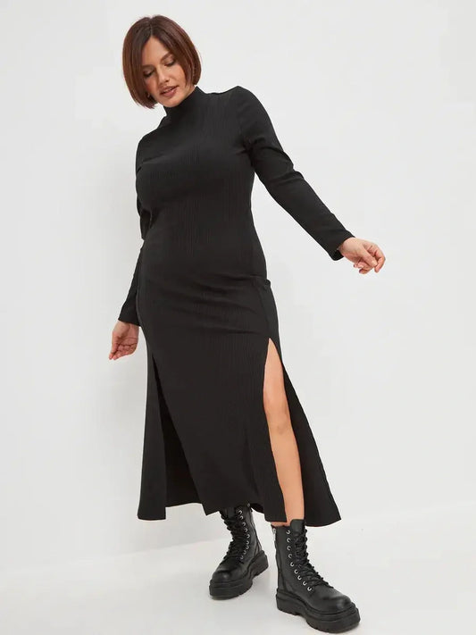 Black midi dress with ribbed texture and side slit, styled with combat boots for a chic, modern look.