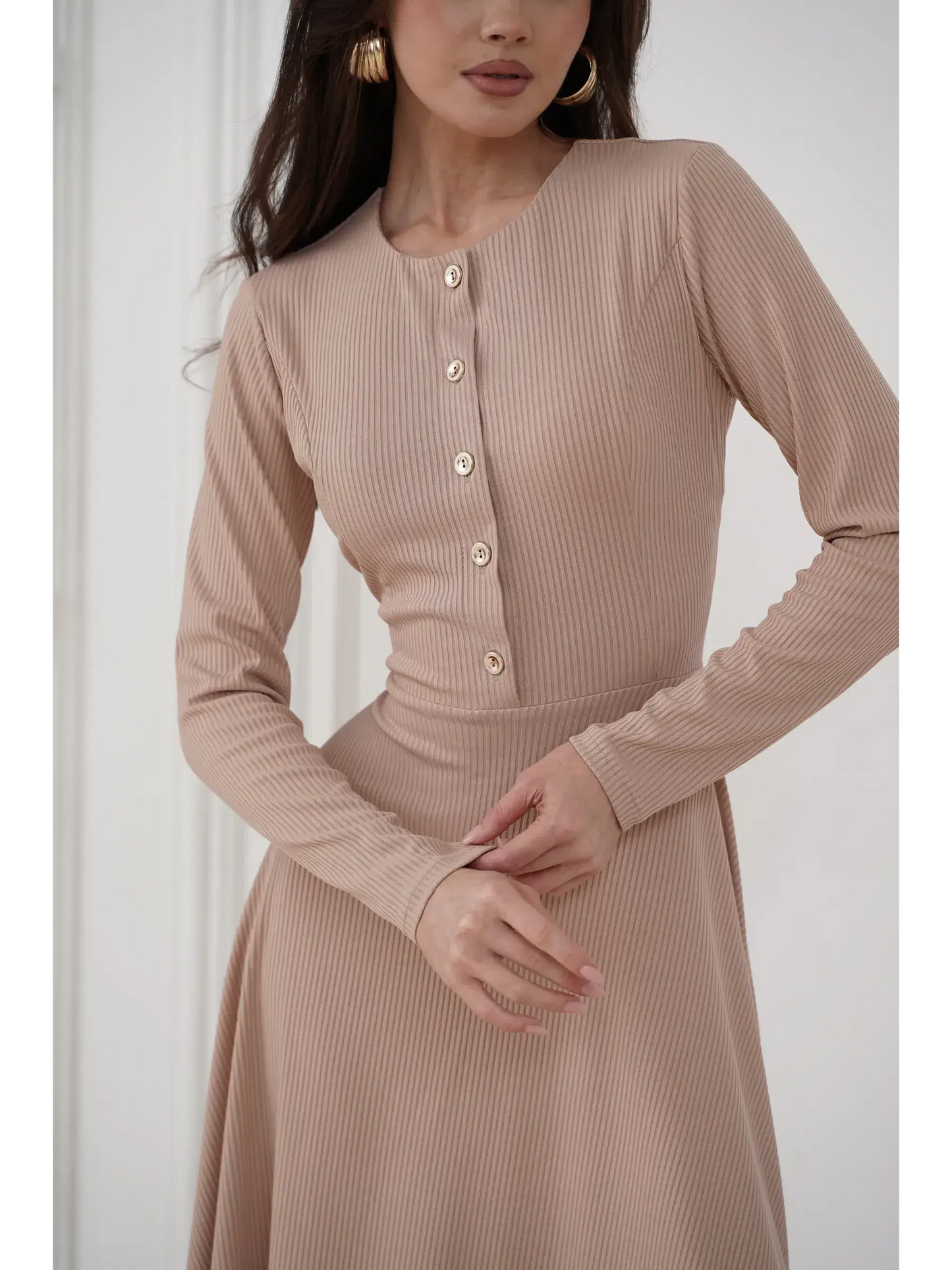 Elegant sculpted midi dress in smooth beige ribbed knit with gold-tone buttons, perfect for formal and casual occasions.