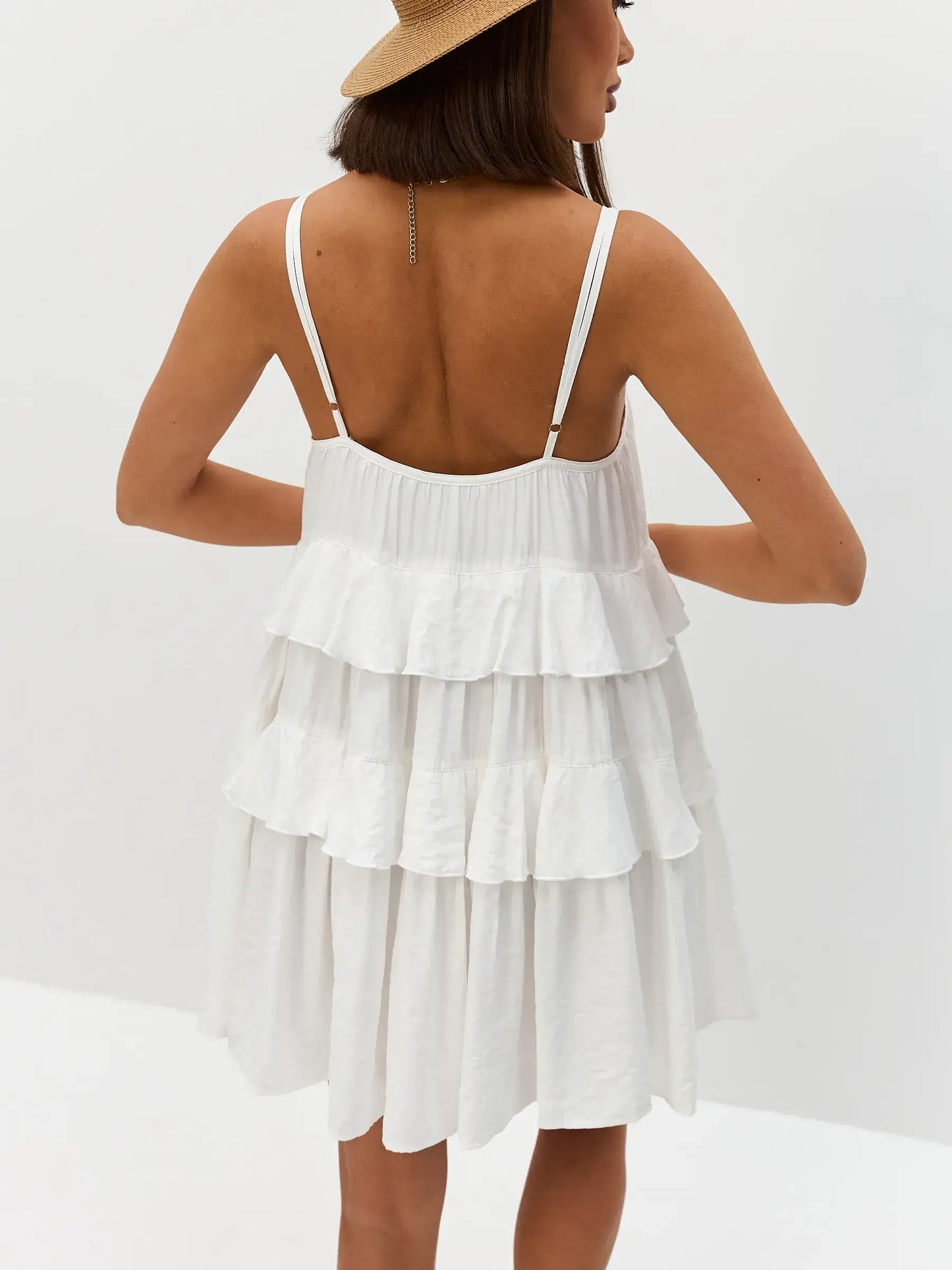 Back view of a tiered white summer dress with delicate shoulder straps, perfect for weddings and casual outings.