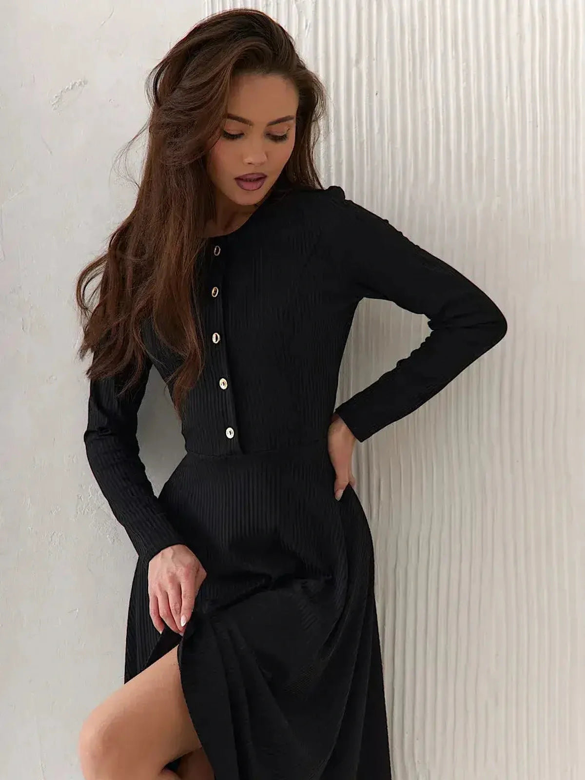 Model showcasing the Serene Grace Midi Dress in black ribbed fabric, featuring decorative buttons and a flared skirt.