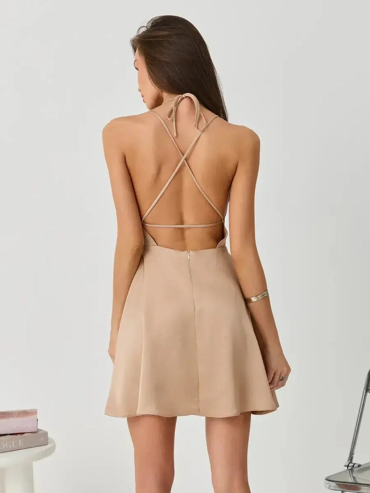 Back view of a nude Satin Whisper mini dress featuring crossed spaghetti straps, ideal for summer occasions.