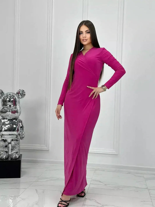 Model wearing a pink Velora Maxi Dress with a wrap silhouette and side slit, showcasing elegance and style.