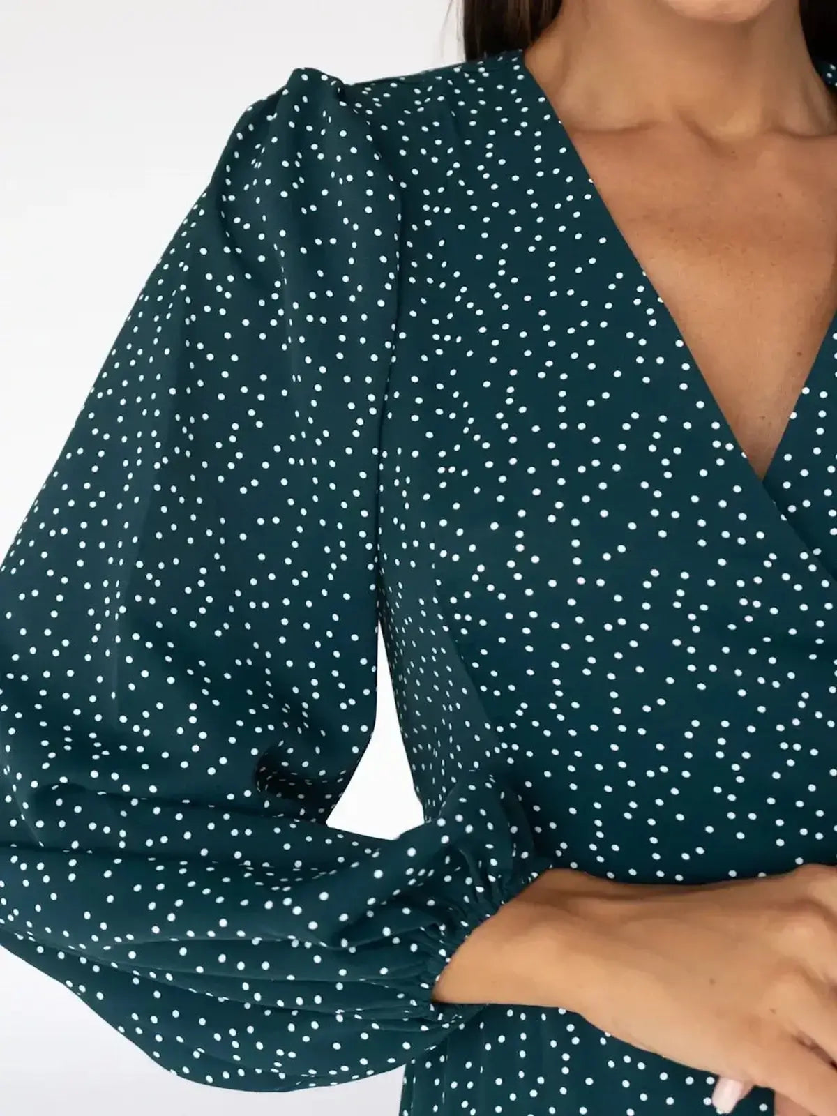 Close-up of Celeste Midi Dress featuring polka dot pattern and deep V-neck, elegant wrap style for women's fashion.
