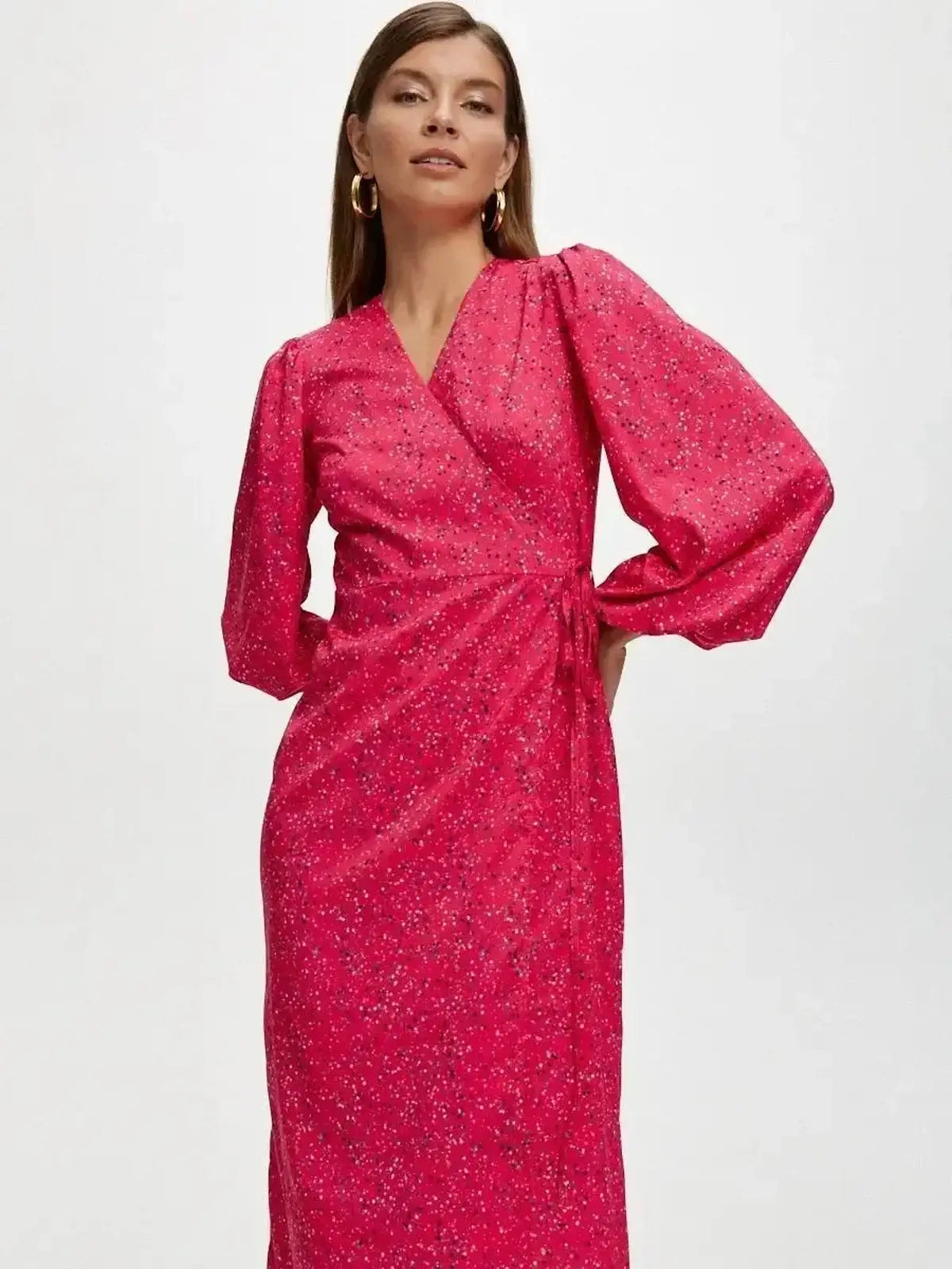 Vibrant pink Confetti Bloom Midi Dress featuring a wrap silhouette and playful print, perfect for weddings and summer events.