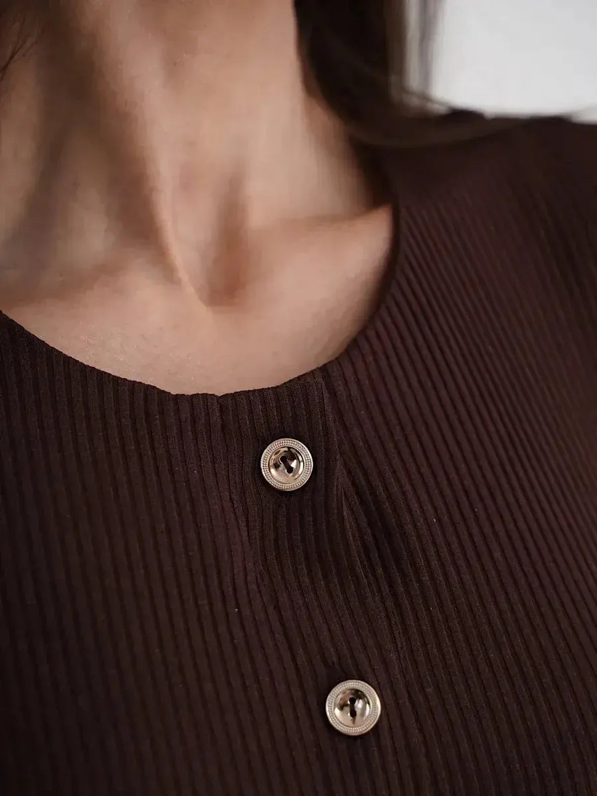 Close-up of the button detailing on the elegant brown Midi Dress Noirette, showcasing its ribbed texture.
