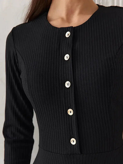 Close-up of the Serene Grace Midi Dress, featuring a black ribbed fabric and decorative buttons for an elegant touch.
