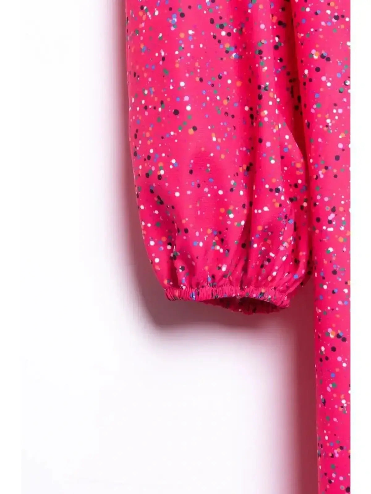 Close-up of the vibrant pink sleeve of the Confetti Bloom Midi Dress featuring a playful speckled print.