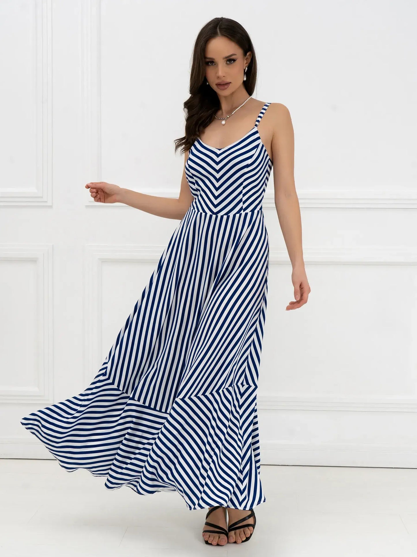 Marina Stripe Maxi Dress with bold stripes and open-back bow detail, perfect for summer events and weddings.