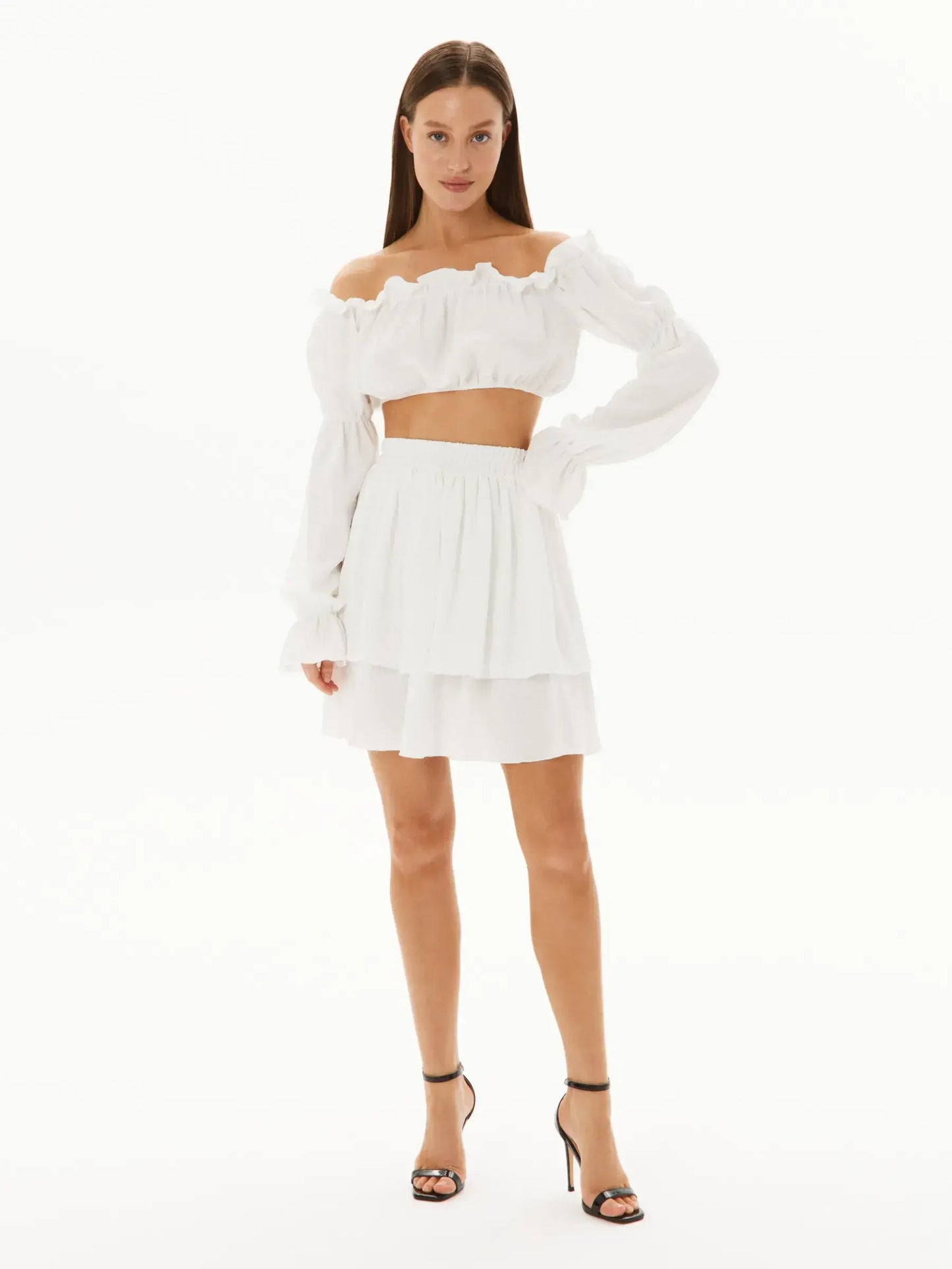 White ruffle set featuring an off-shoulder top and layered mini skirt, perfect for summer events and chic outings.