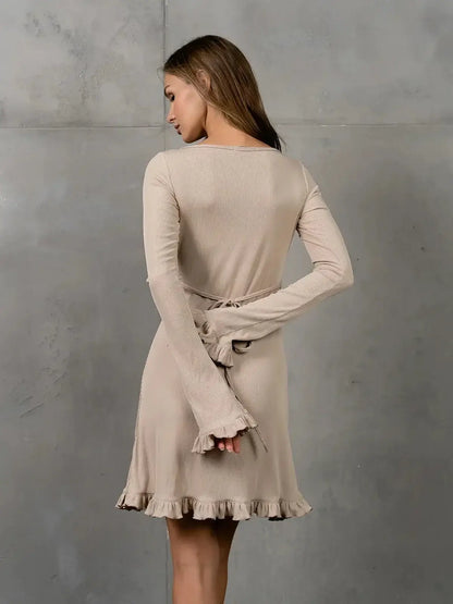 Back view of a beige Luna Flare dress, featuring a body-contouring cut and ruffled hem, perfect for summer or wedding guest attire.
