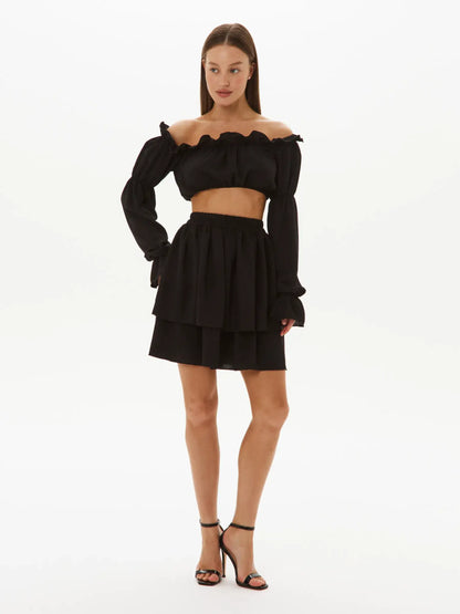 Stylish Ruffle Muse Set featuring an off-shoulder top and tiered mini skirt, perfect for summer events and weddings.