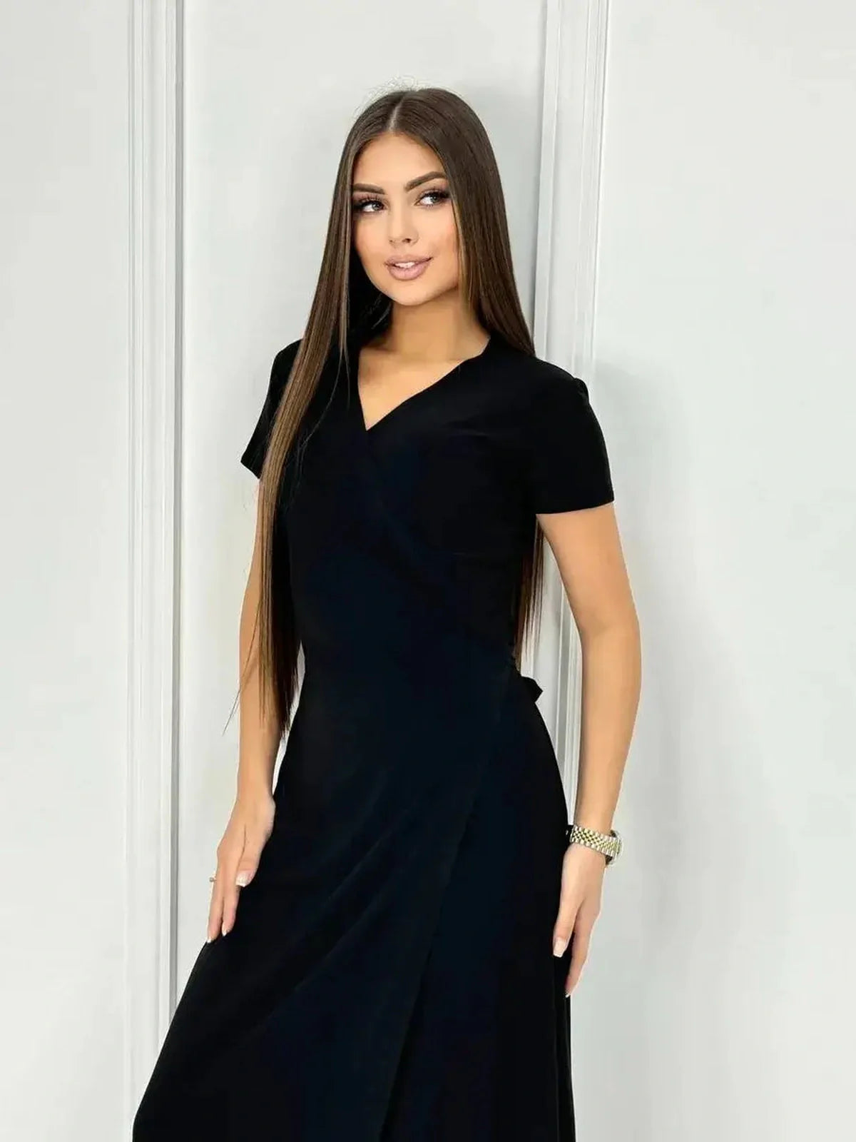 Woman modeling the Obsidian Grace Maxi Dress, showcasing its elegant wrap silhouette in classic black.