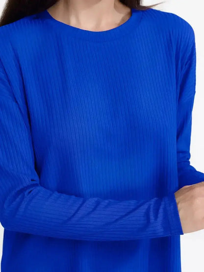 Woman wearing an electric blue ribbed knit top from an Electric Lounge Set, showcasing relaxed elegance and comfort.